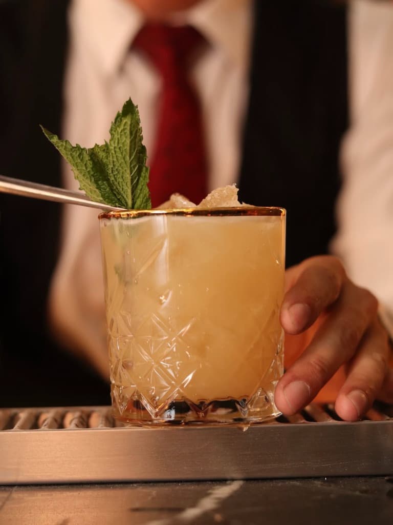 Cóctel dorado con menta
